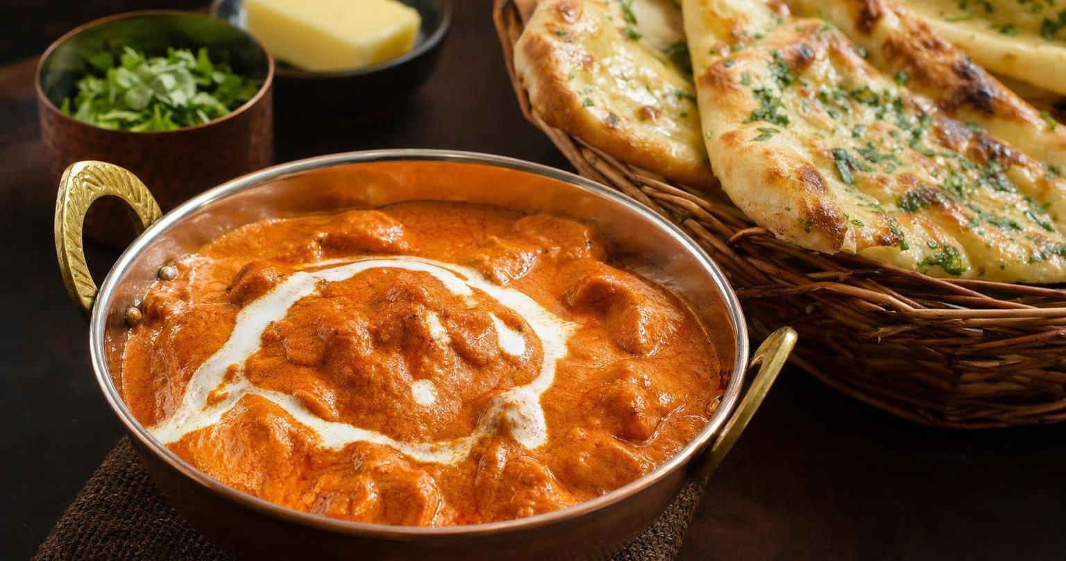 Curry cremoso con pan naan de ajo y cilantro (imagen generada con AI)