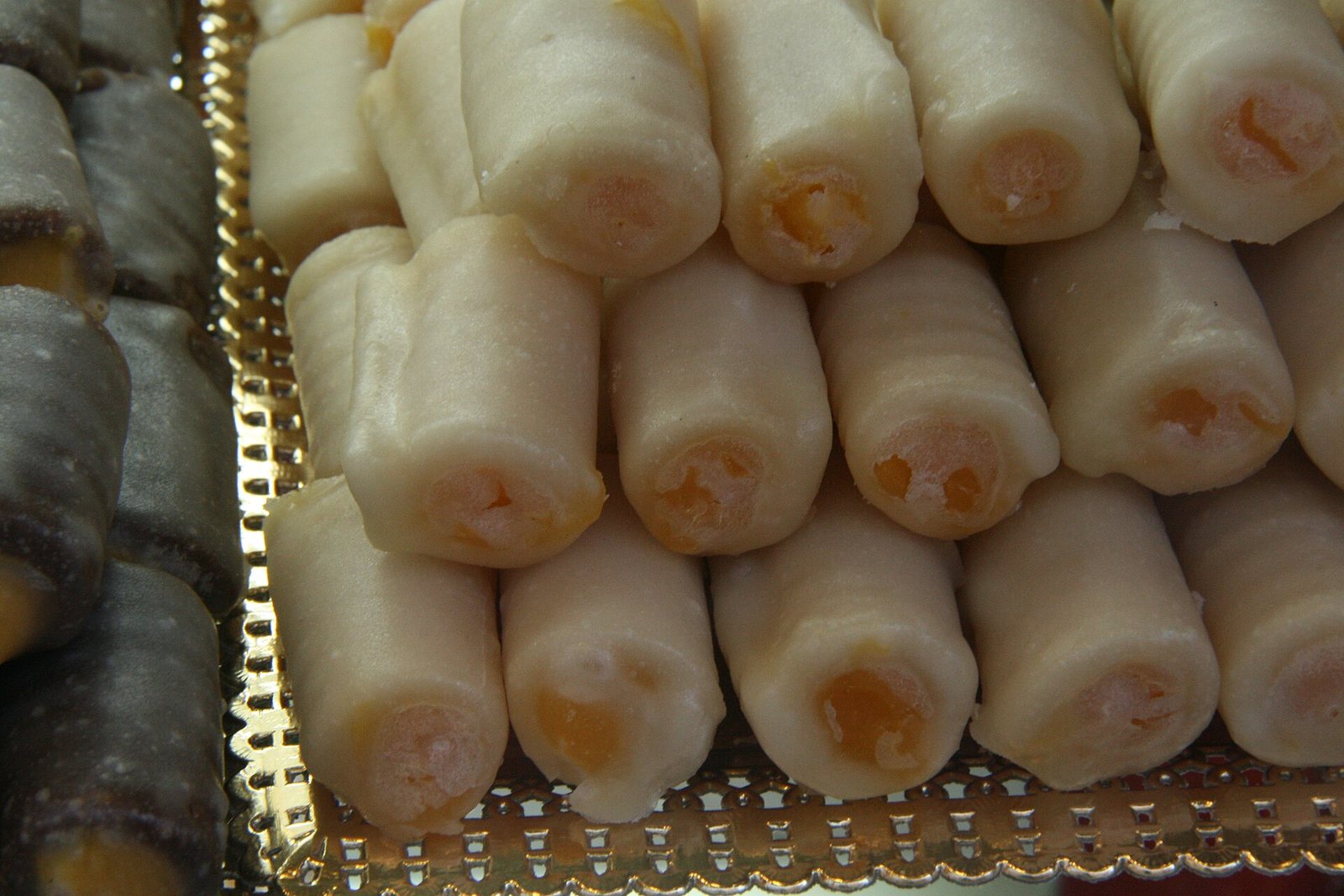 Huesos de santo de mazapán rellenos de yema en una bandeja de pastelería